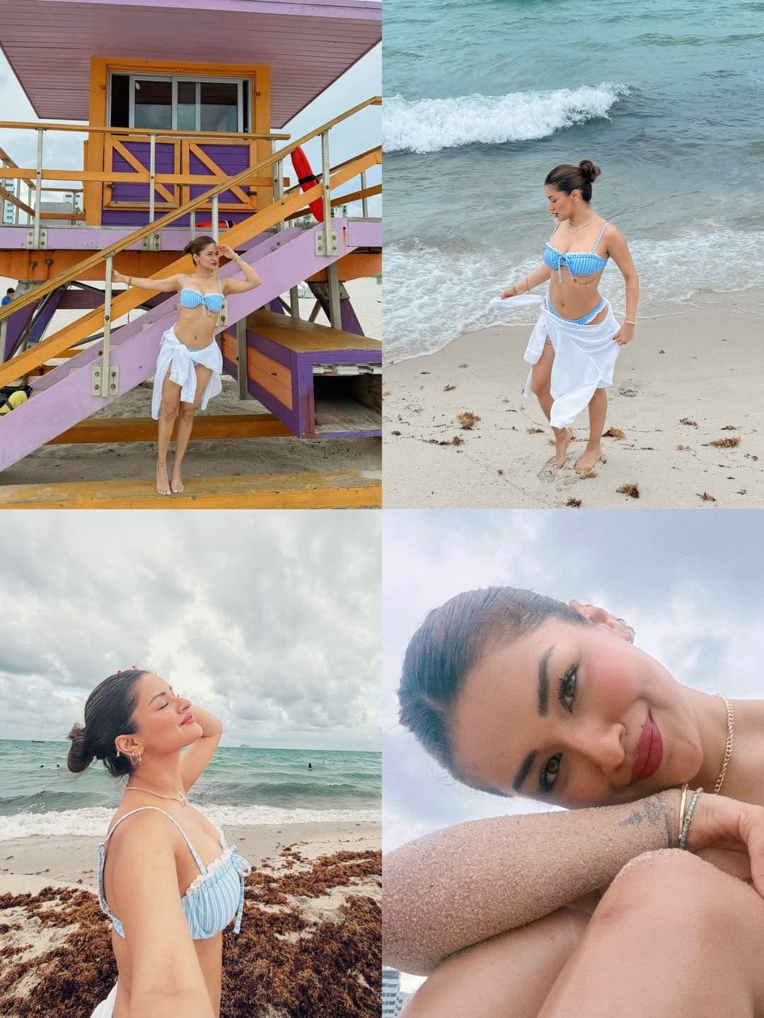 Avneet Kaur posing on a Miami beach in a blue striped bikini and white sarong, with a colorful lifeguard stand and ocean waves in the background.