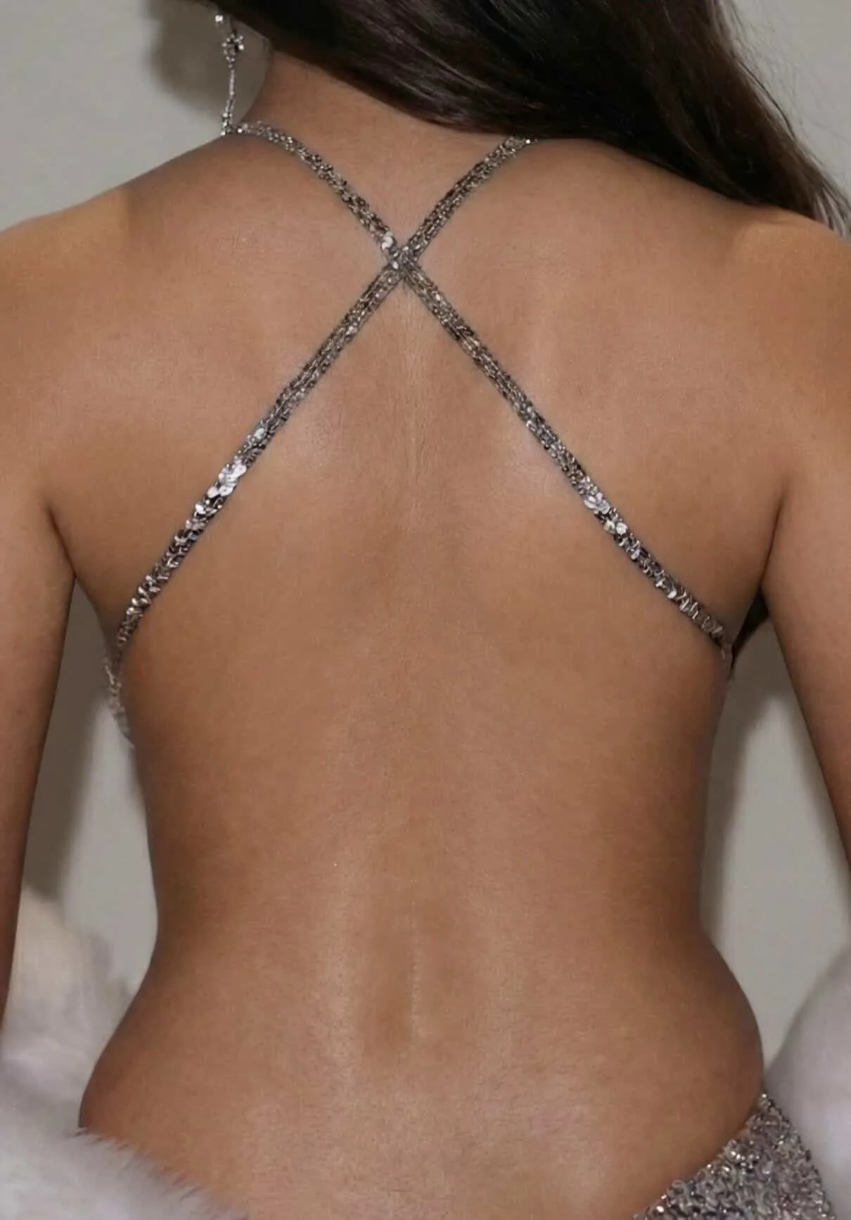 Back view of Alia Bhatt showing her bare back in a backless silver sequined criss-cross top