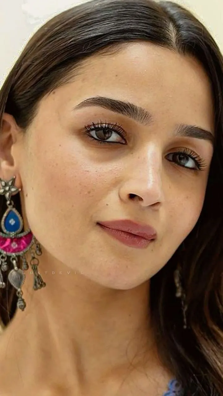 Close-up portrait of Alia Bhatt wearing traditional blue and pink silver earrings.