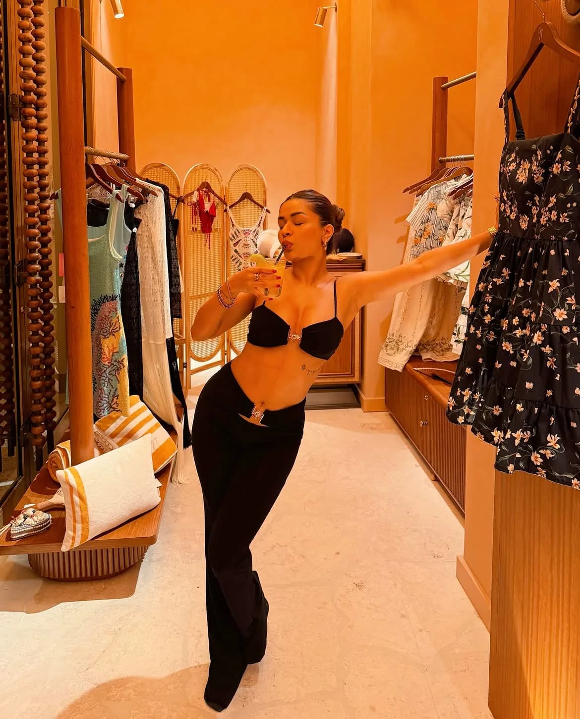 Avneet Kaur posing in a black bralette crop top and low-waist trousers in a boutique.