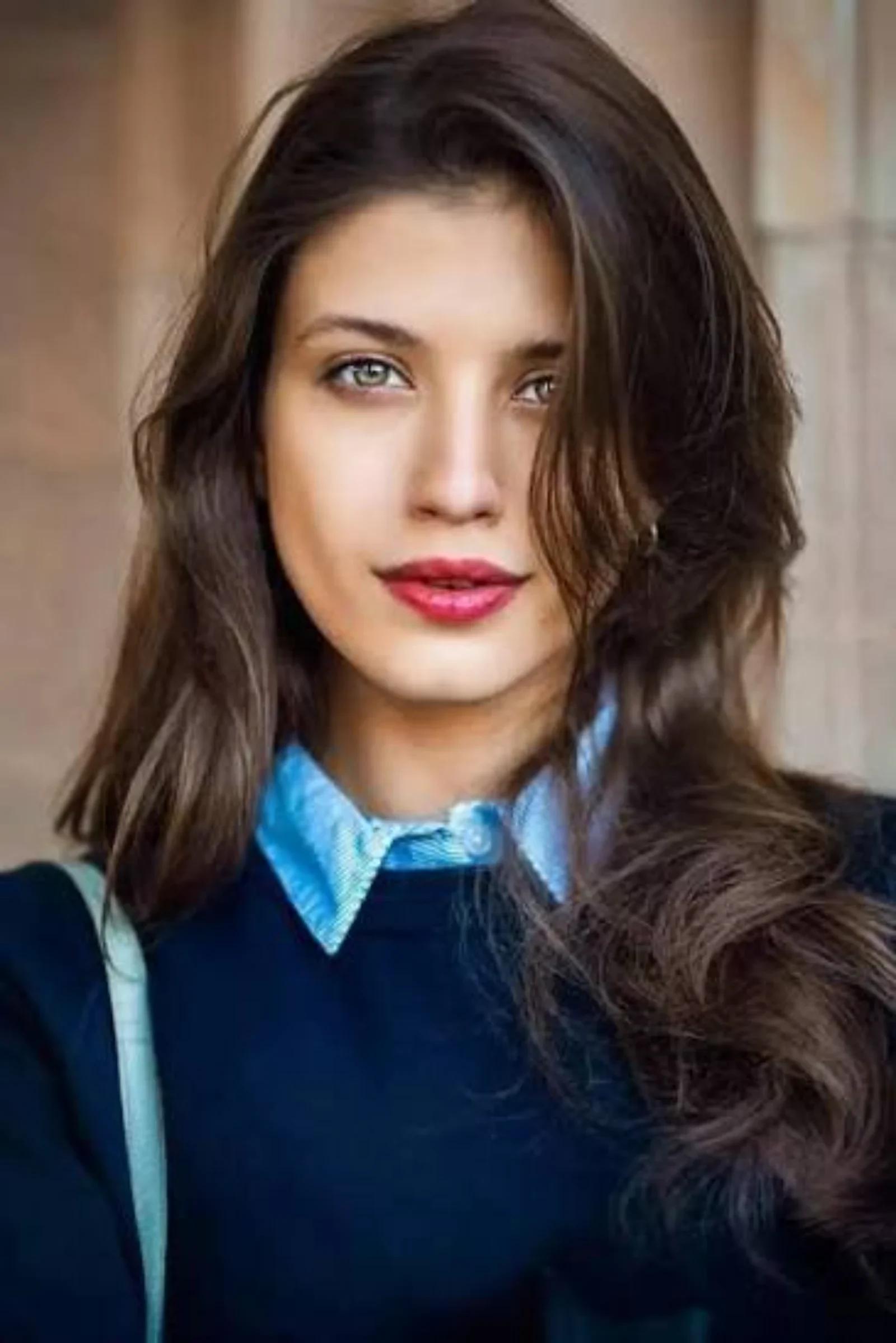 Anna Chipovskaya smiling in a casual blue outfit during an outdoor portrait session